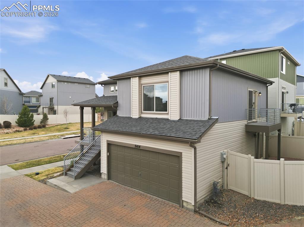 Image 35 of 40: View of property exterior featuring an attached garage, roof with shingles,