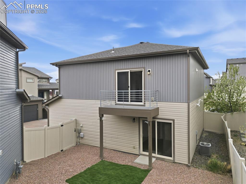 Image 36 of 40: Back of house featuring a fenced backyard, a shingled roof, a patio area, a