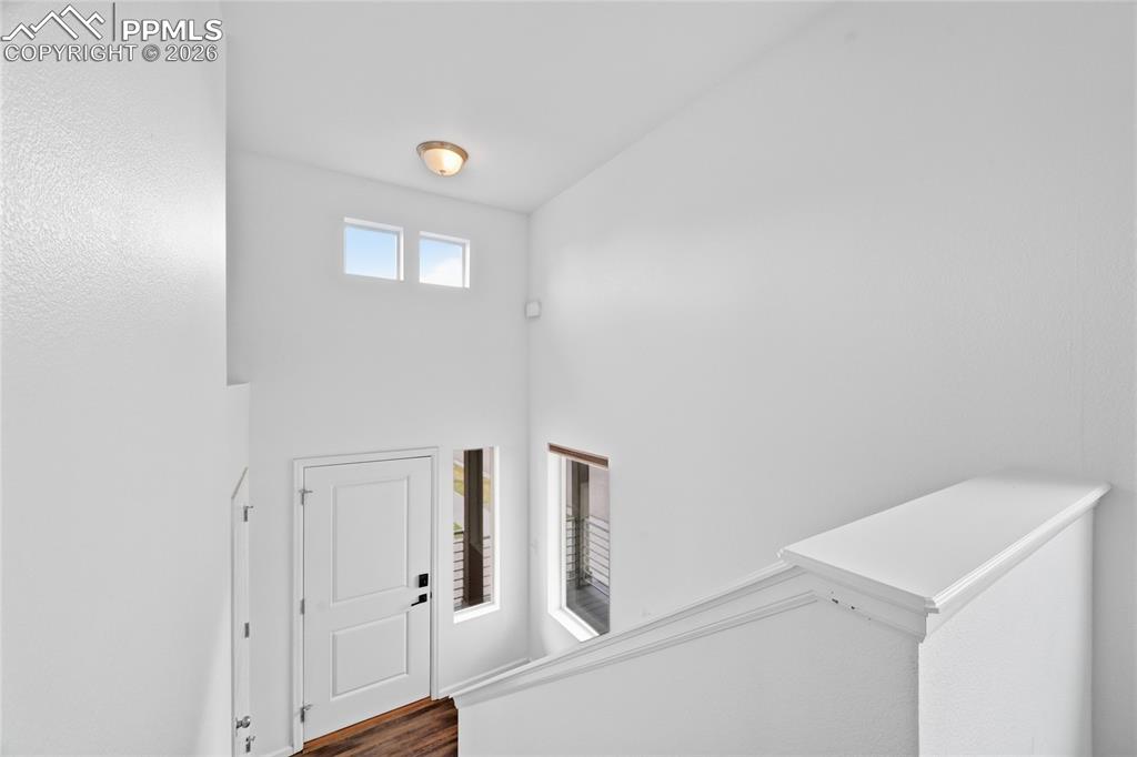 Image 6 of 40: Foyer featuring dark luxury vinyl wood finished floors and a high ceiling