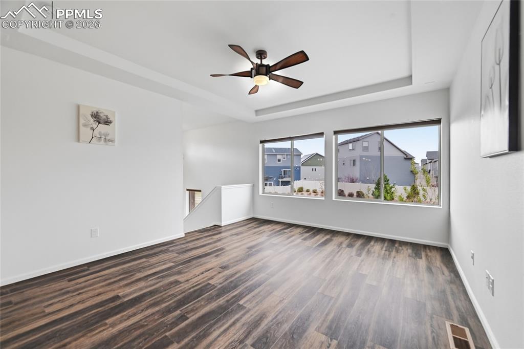 Image 8 of 40: Unfurnished living room featuring two big windows, a raised ceiling, a ceil