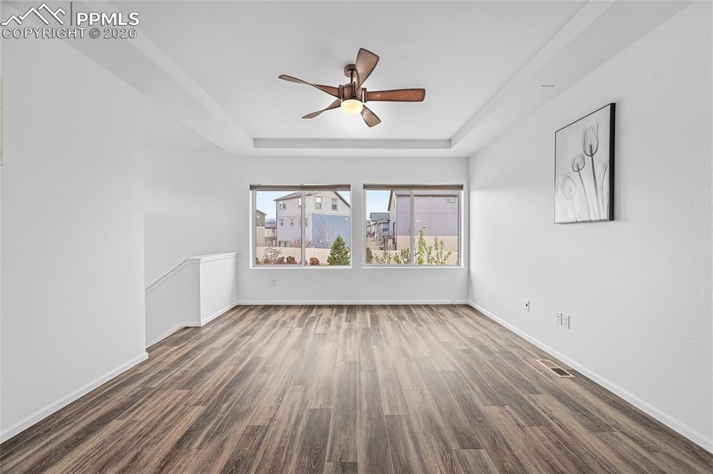 Image 9 of 40: Unfurnished living room featuring two big windows, a raised ceiling, a ceil