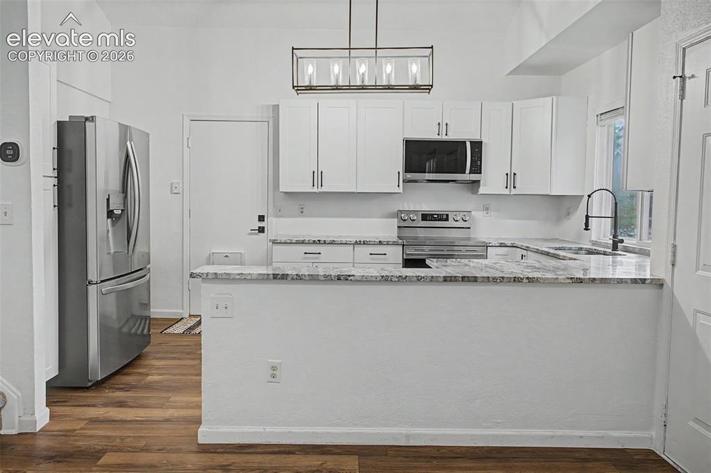 Image 12 of 37: Kitchen featuring white cabinetry, light-toned countertops, a stainless ste