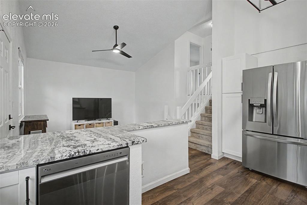 Image 14 of 37: Kitchen area featuring wood-finish flooring, stainless steel appliances, an