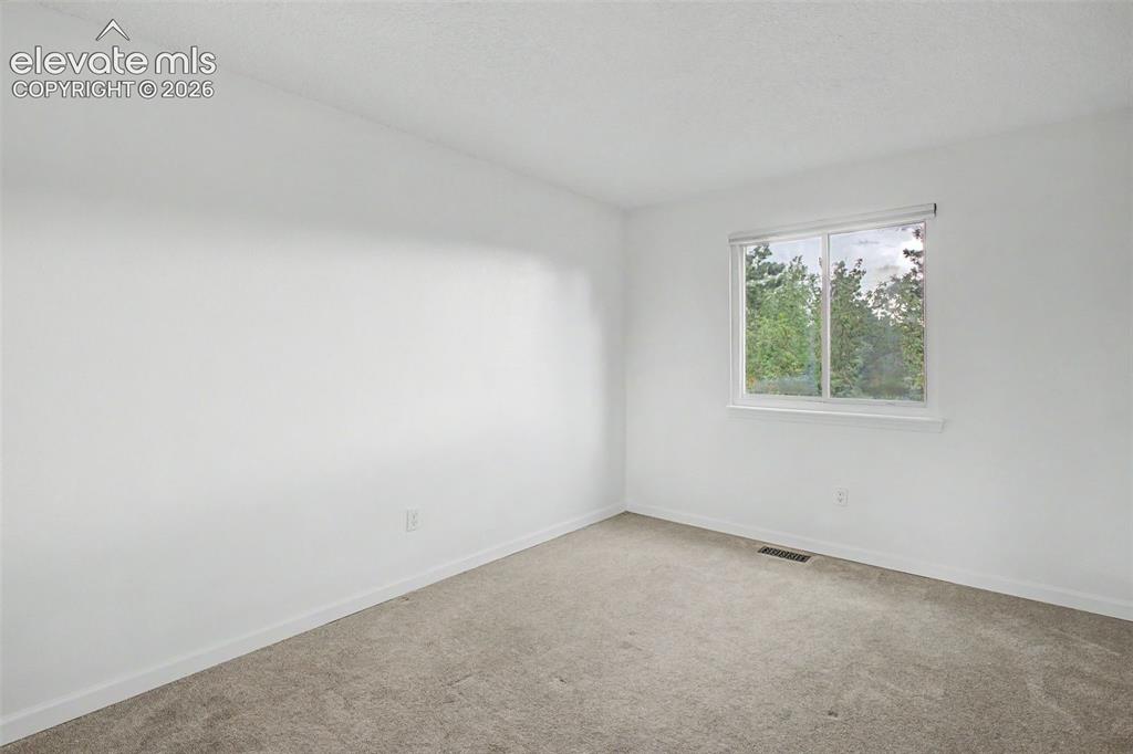 Image 17 of 37: Bright room featuring neutral wall paint, light-colored carpet, and a windo