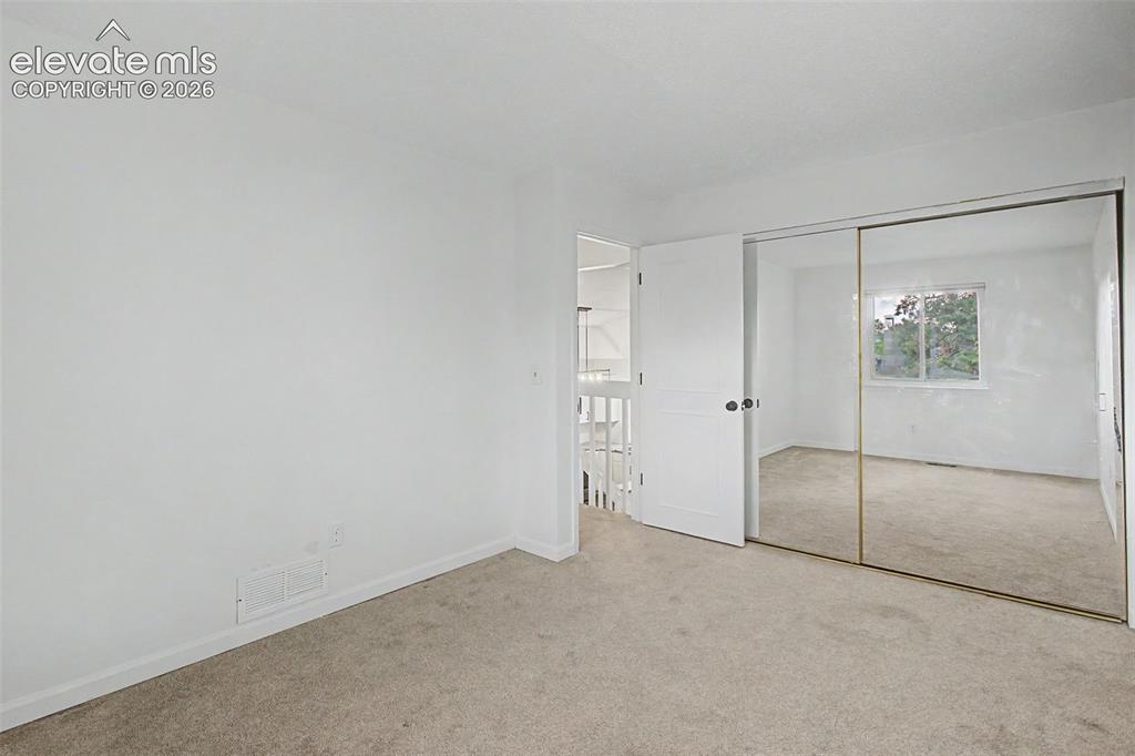 Image 19 of 37: Spacious room featuring neutral carpeting, white walls, a single window, an