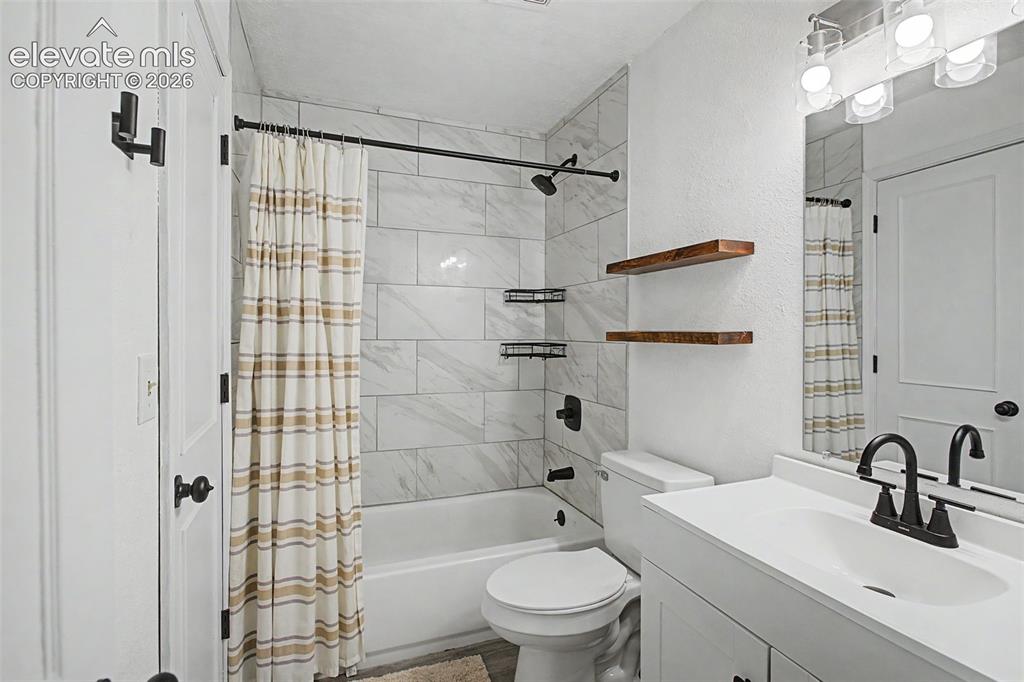 Image 22 of 37: Bathroom featuring a white vanity with a single basin sink and matte black