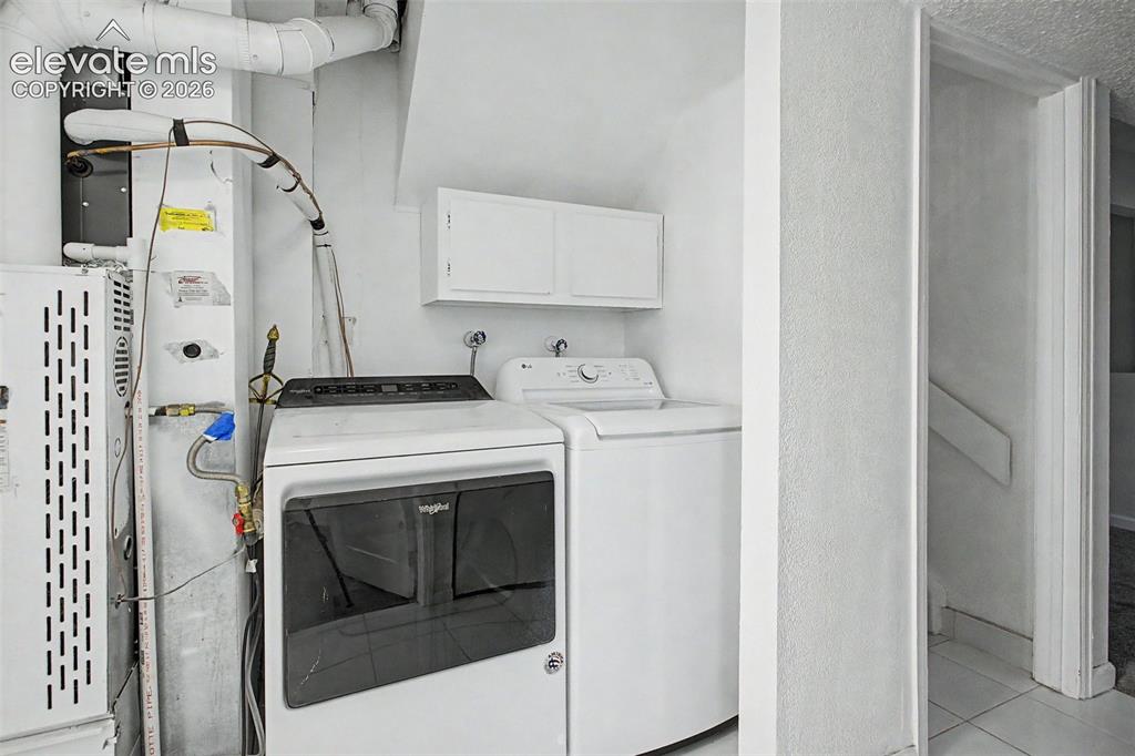 Image 26 of 37: Dedicated laundry area featuring a white top-load washing machine and a whi