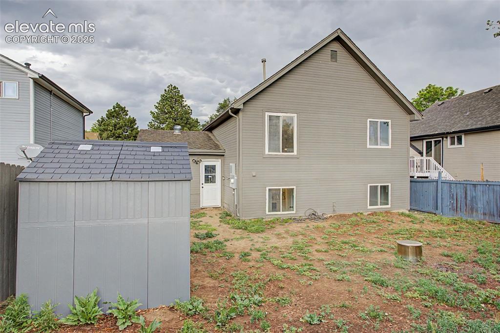 Image 27 of 37: Rear elevation featuring gray horizontal siding and multiple windows, compl