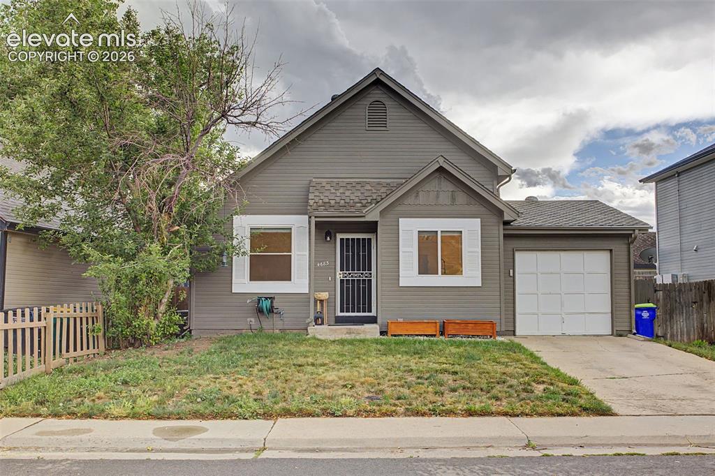 Image 36 of 37: Gray siding exterior featuring white window trim and a partial picket fence