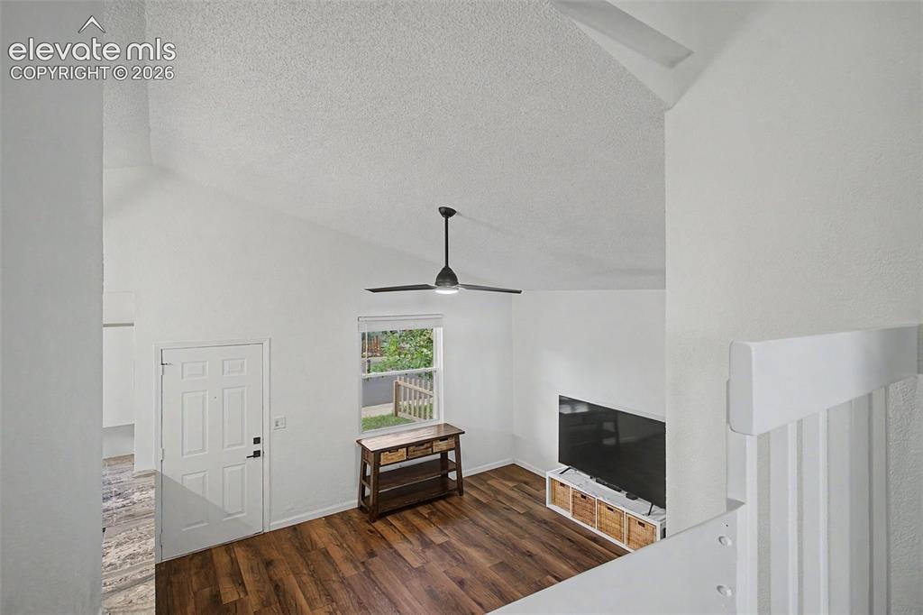 Image 9 of 37: Vaulted ceilings featuring a ceiling fan, wood-finish flooring, and a panel