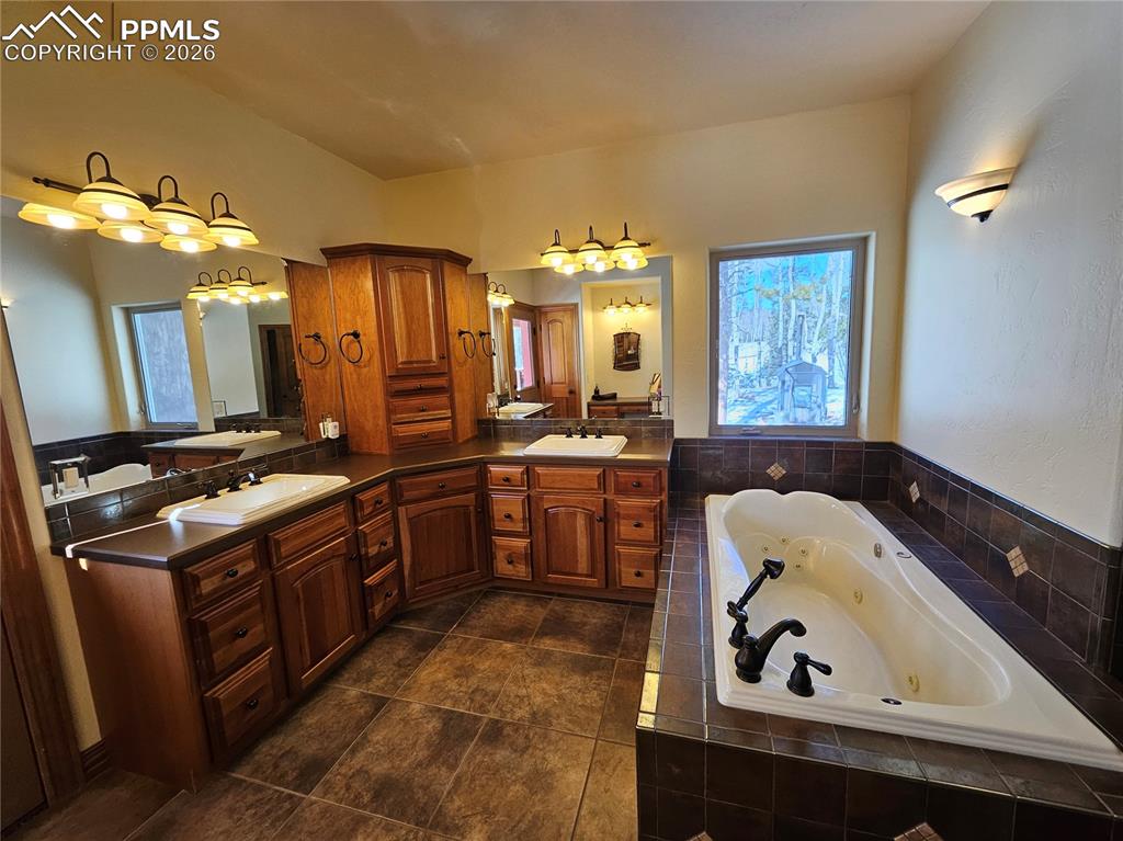 Image 14 of 48: Bathroom featuring a jetted tub and double vanity