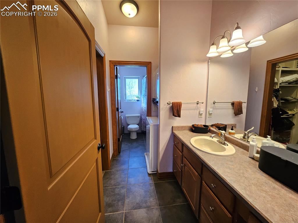 Image 22 of 48: Bathroom upstairs featuring vanity, dark tile patterned flooring, and a spa