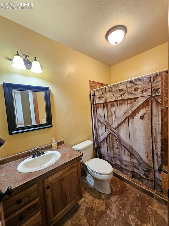 Image 27 of 48: Bathroom in basement with vanity and curtained shower