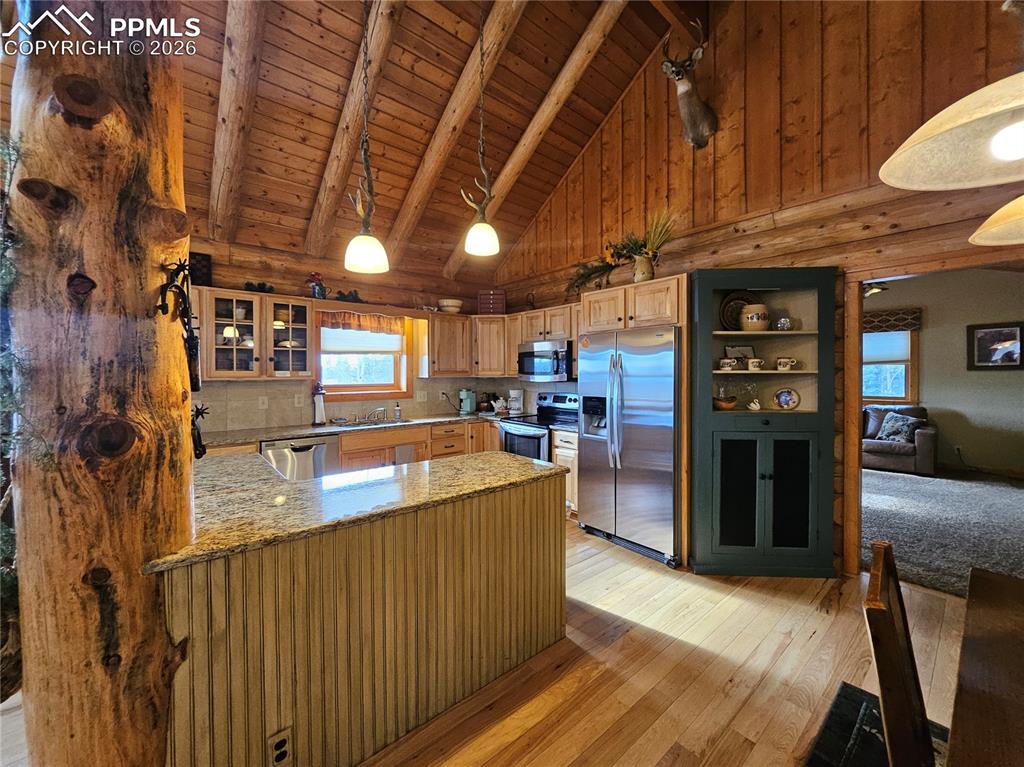 Image 34 of 48: Kitchen featuring glass insert cabinets, a high wood beamed ceiling, a peni