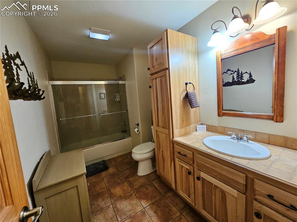 Image 45 of 48: Cabin basement full bathroom featuring vanity, shower / bath combination wi