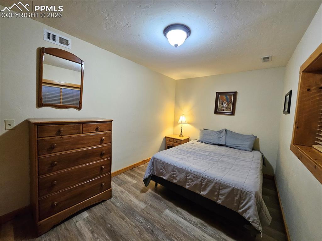 Image 47 of 48: Cabin bedroom in basement with wood-style flooring