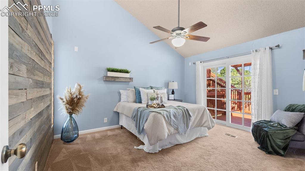 Image 15 of 38: Primary bedroom has vaulted ceilings and its own door to the amazing deck.