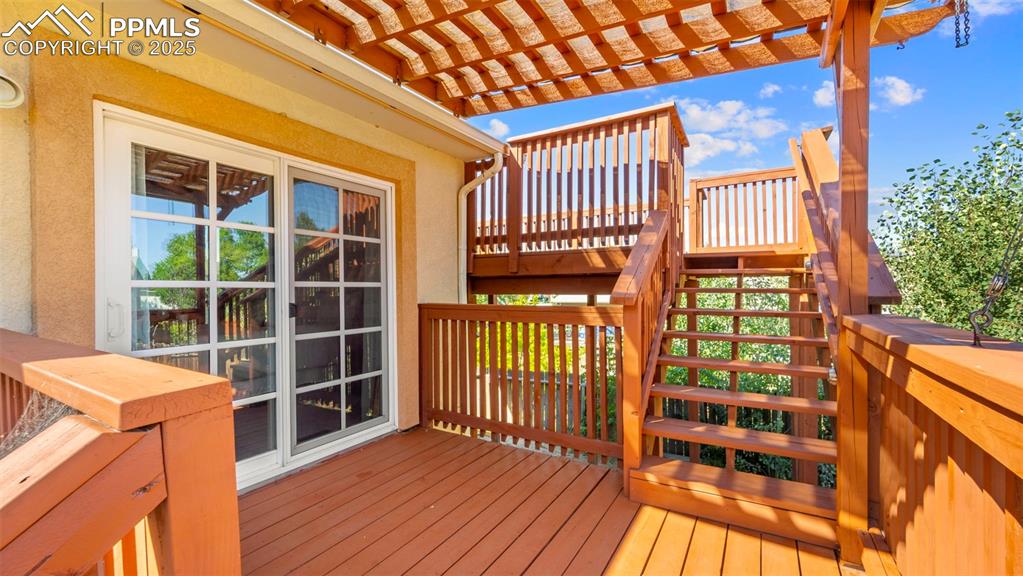Image 30 of 38: Deck has stairs up from the back yard or direct access from the Primary bed
