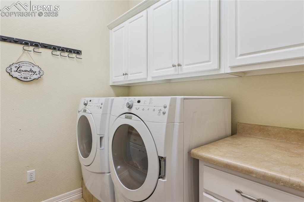 Image 13 of 41: Laundry room featuring cabinet space and separate washer and dryer