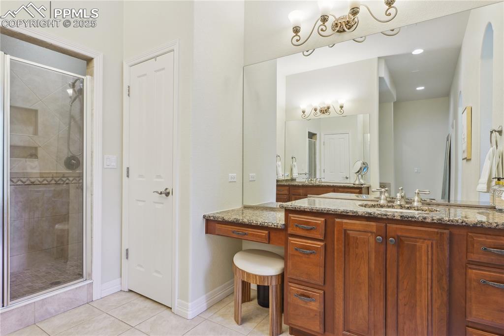 Image 18 of 41: Full bath featuring vanity, baseboards, a shower stall, and tile patterned