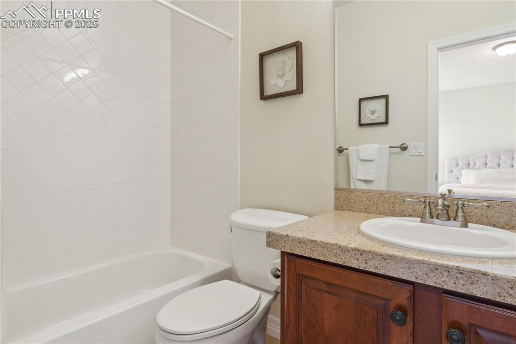Image 22 of 41: Full bath featuring toilet, vanity, and shower / washtub combination