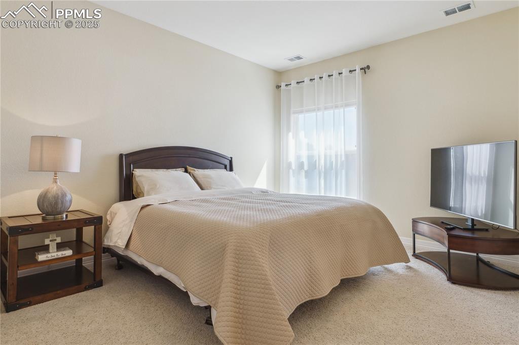 Image 23 of 41: Bedroom with baseboards, visible vents, and carpet floors