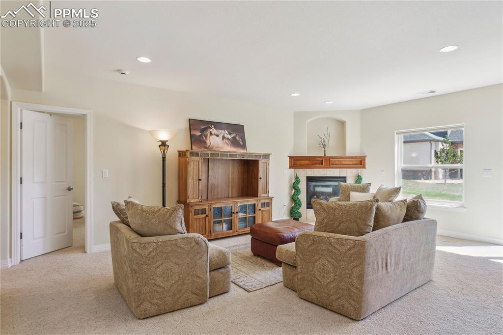 Image 25 of 41: Living area featuring carpet flooring, visible vents, a fireplace, and base
