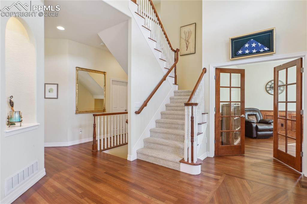 Image 3 of 41: Staircase featuring wood finished floors, french doors, visible vents, base