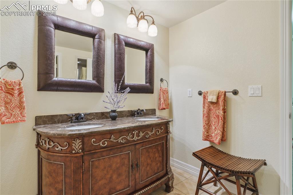Image 31 of 41: Bathroom with a sink, double vanity, and tile patterned floors