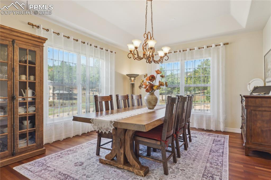 Image 4 of 41: Dining area with a notable chandelier, baseboards, and wood finished floors
