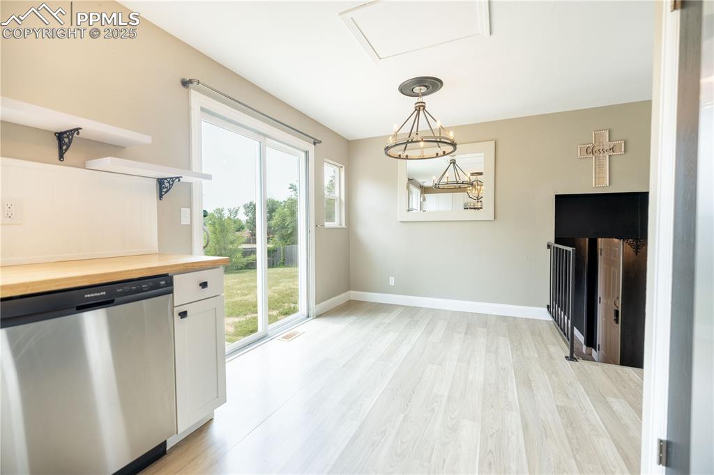 Image 10 of 28: Kitchen with stainless steel dishwasher, wooden counters, light wood-style 