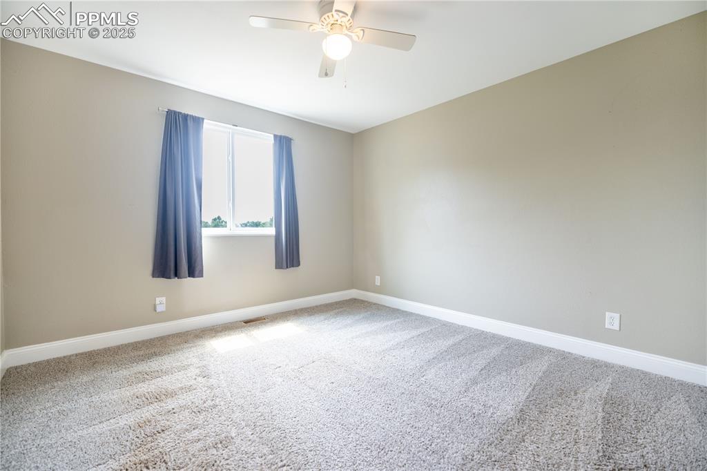 Image 13 of 28: Upstairs Carpeted primary bedroom faces backyard
