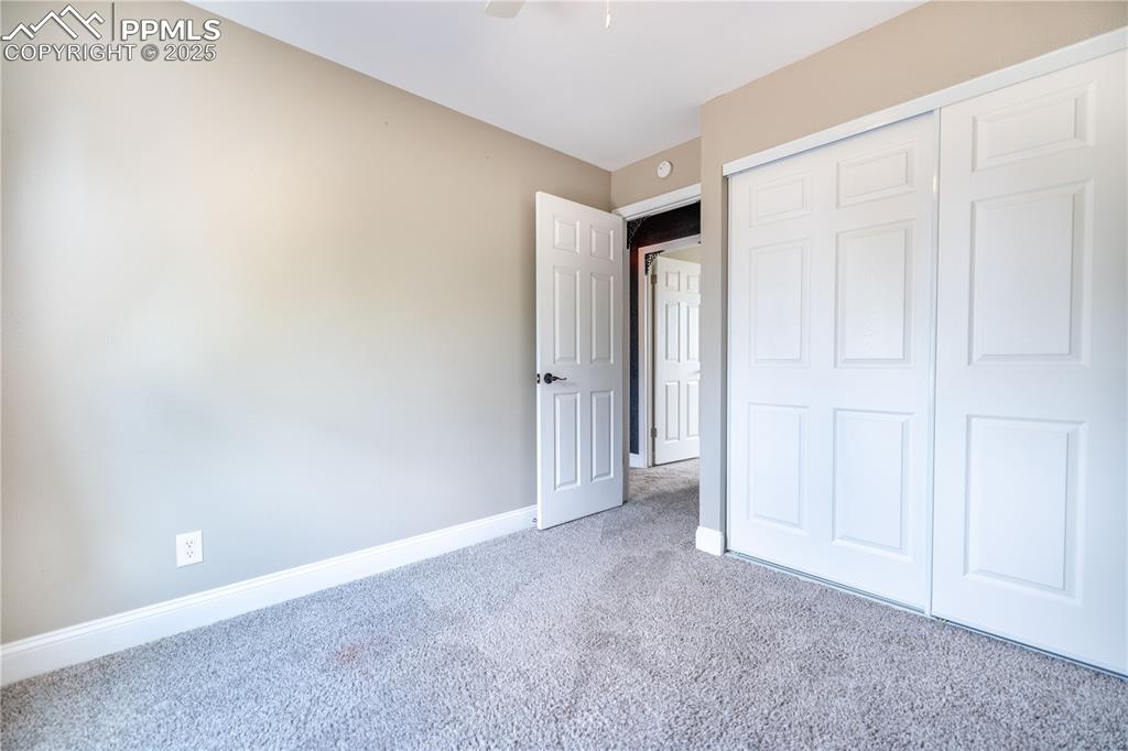 Image 17 of 28: Upstairs bedroom 3 featuring carpet, a closet, and a ceiling fan
