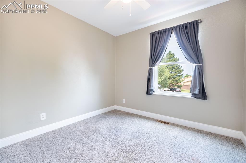 Image 18 of 28: Upstairs bedroom 3 featuring carpet, a closet, and a ceiling fan