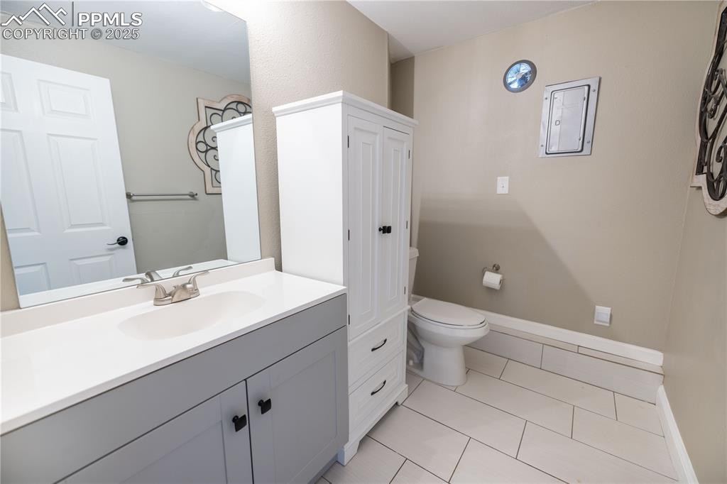 Image 24 of 28: Lower level Bathroom with vanity and tile patterned floors