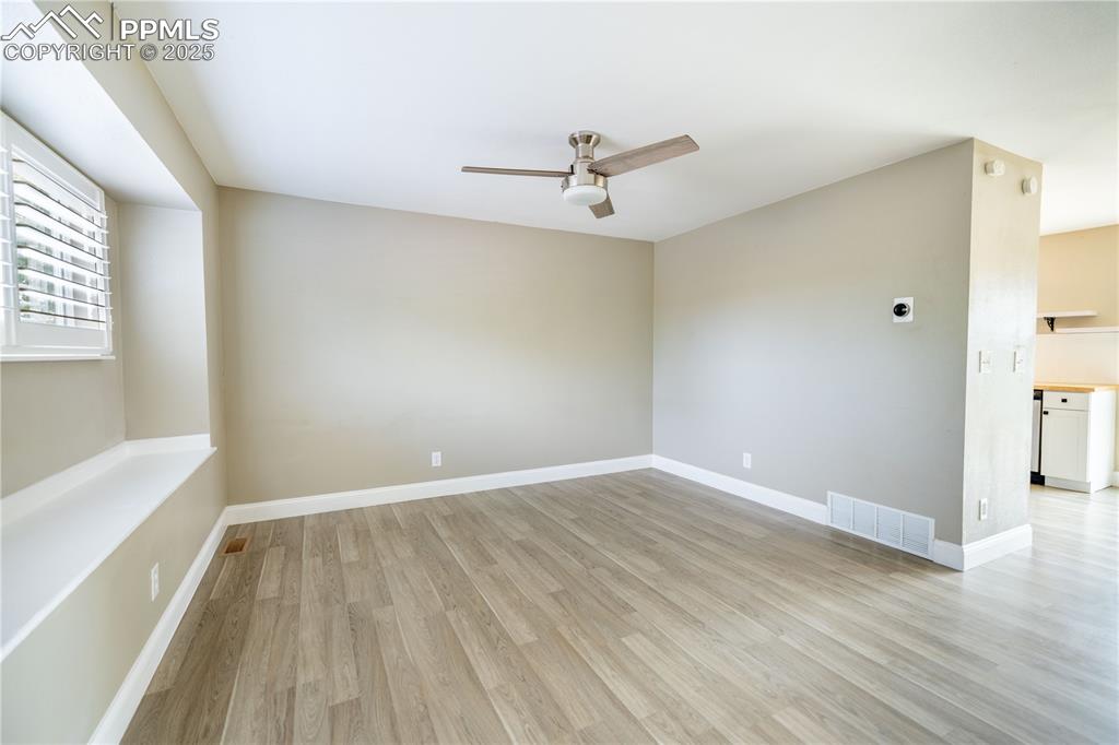Image 3 of 28: Living room with ceiling fan and light wood-laminate floors