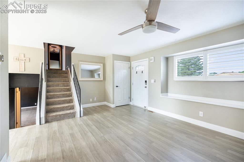Image 6 of 28: Entryway featuring light wood-laminate flooring, stairway, and ceiling fan