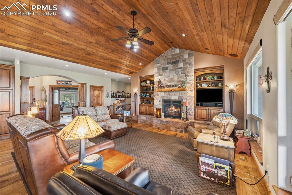 Image 12 of 45: Vaulted wood ceiling with gas fireplace and built in shelves and lower cabi
