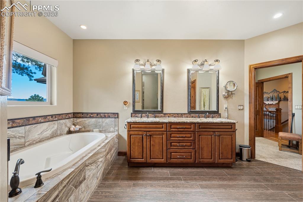 Image 20 of 45: Granite counter tops, tile flooring and tub backsplash