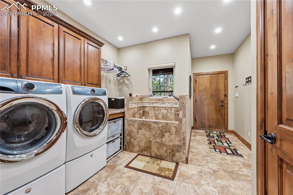 Image 22 of 45: Entry from garage into laundry with a pet bath. Also note folding area, ha