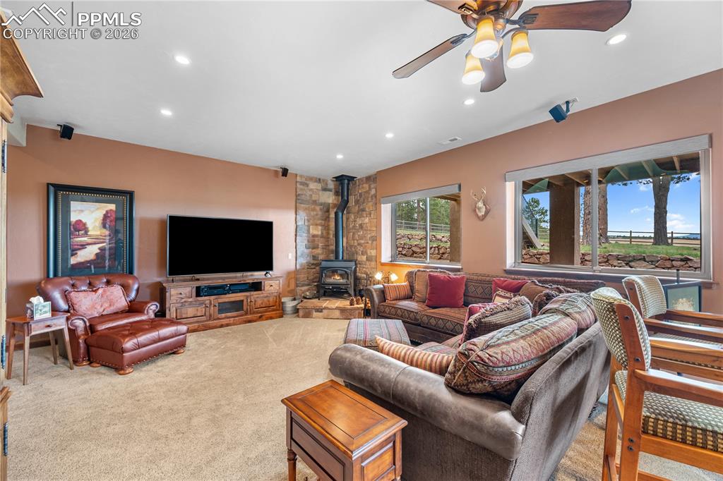 Image 24 of 45: View from wet bar area. Corner wood burning stove. Fireplace accessories