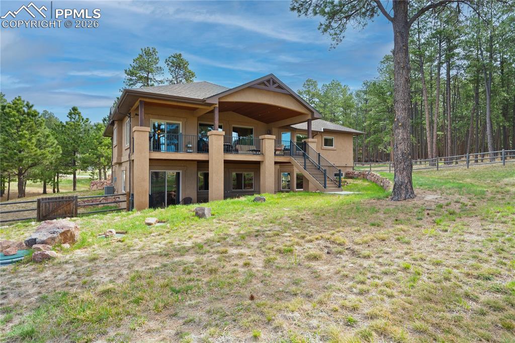 Image 38 of 45: Covered deck and lower patio with large fenced area