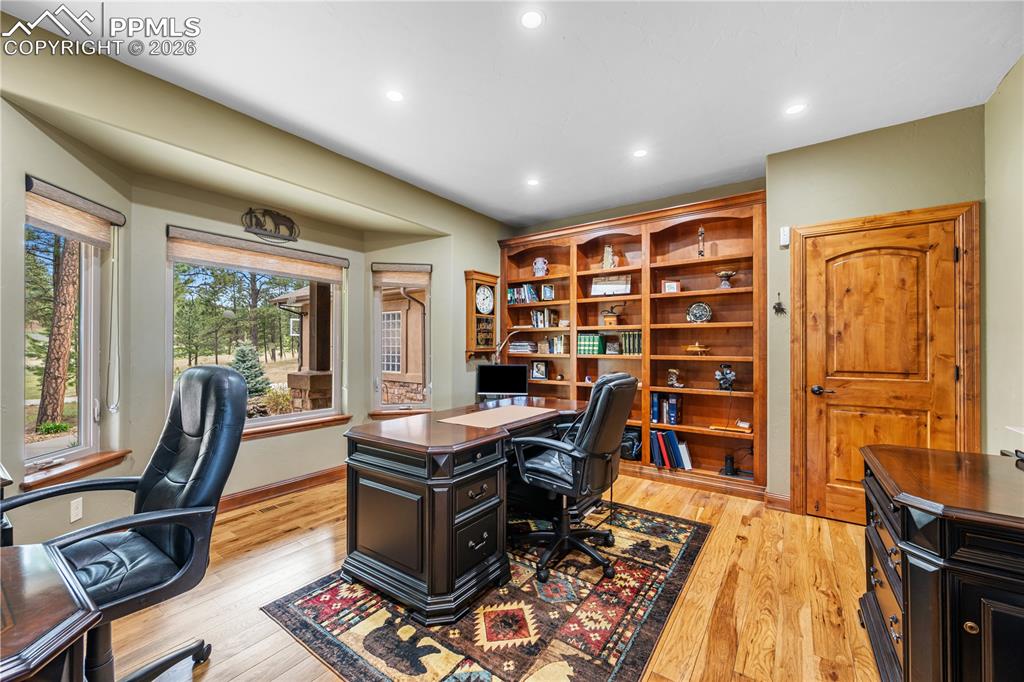 Image 7 of 45: Spacious home office with built in wood shelving and closet. View to front