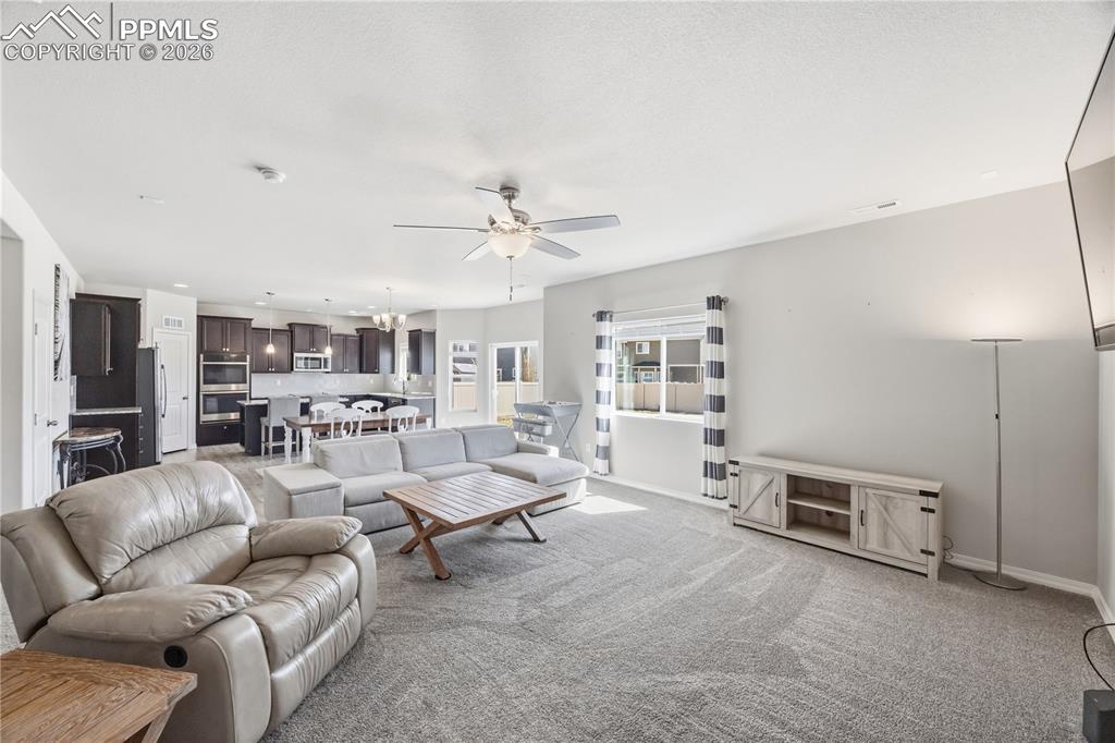 Image 11 of 41: The spacious Living Room features a striking stone-surround fireplace, idea