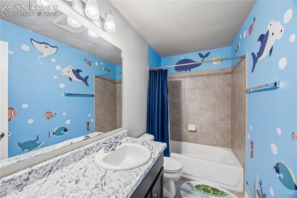 Image 23 of 41: Upper Level Bedroom #2 has neutral carpet and a lighted ceiling fan.