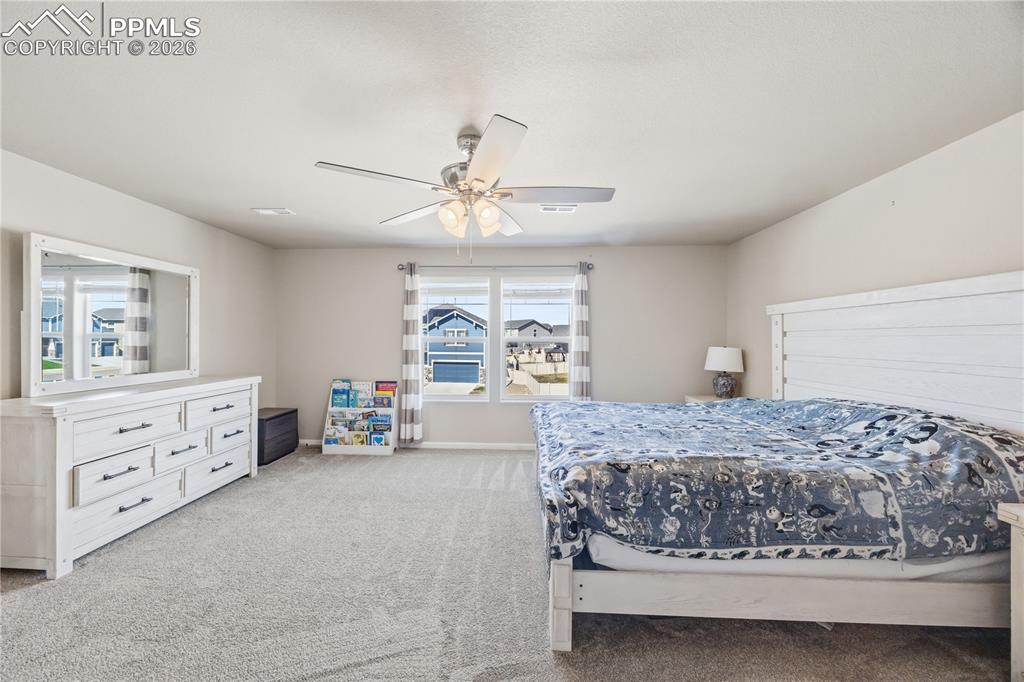 Image 27 of 41: Upper Level Primary Bedroom with front yard views.