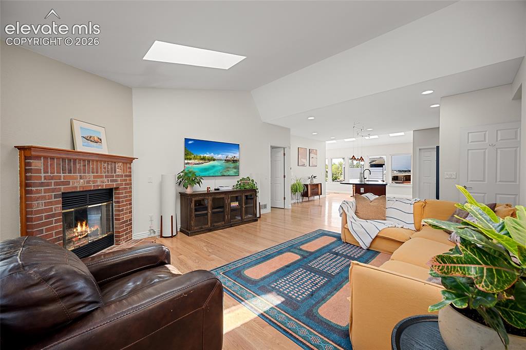Image 2 of 34: Open concept living room with abundant natural light and gas fireplace