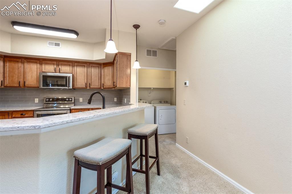 Image 17 of 23: Laundry conveniently located just around the corner from the kitchen, next 