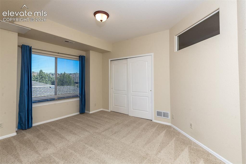 Image 17 of 23: 2nd bedroom with interior glass for additional light from living room