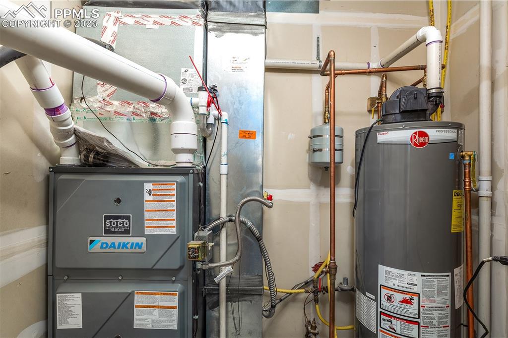 Image 21 of 23: Hot water heater, furnace, and A/C located in utility room off patio